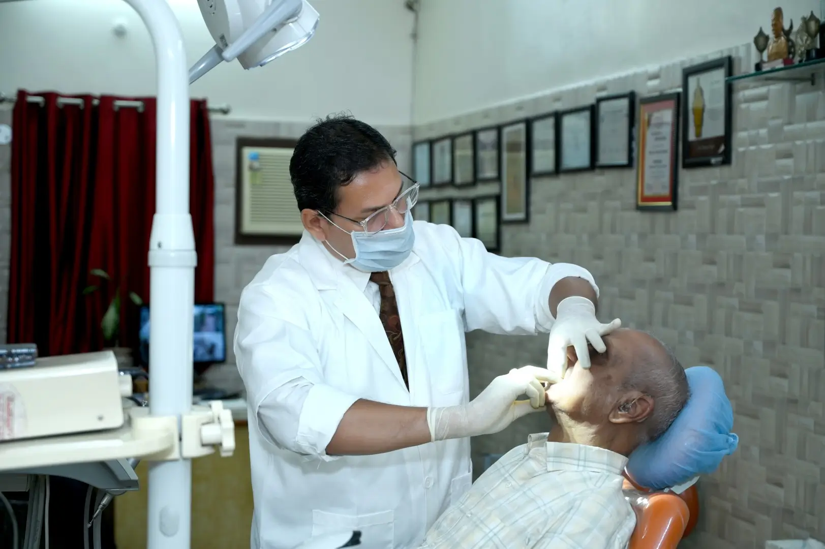 Dr. Gaurav performing dental check‑up on senior patient at Varanasi clinic