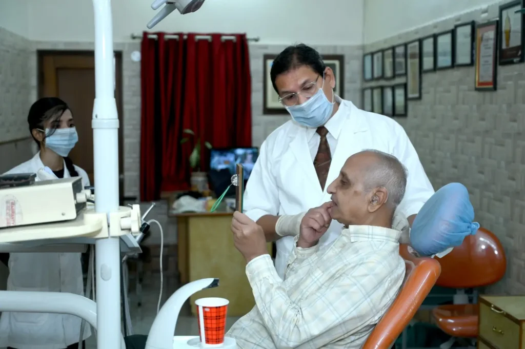 Patient checking smile with mirror during consultation with Dr Gaurav